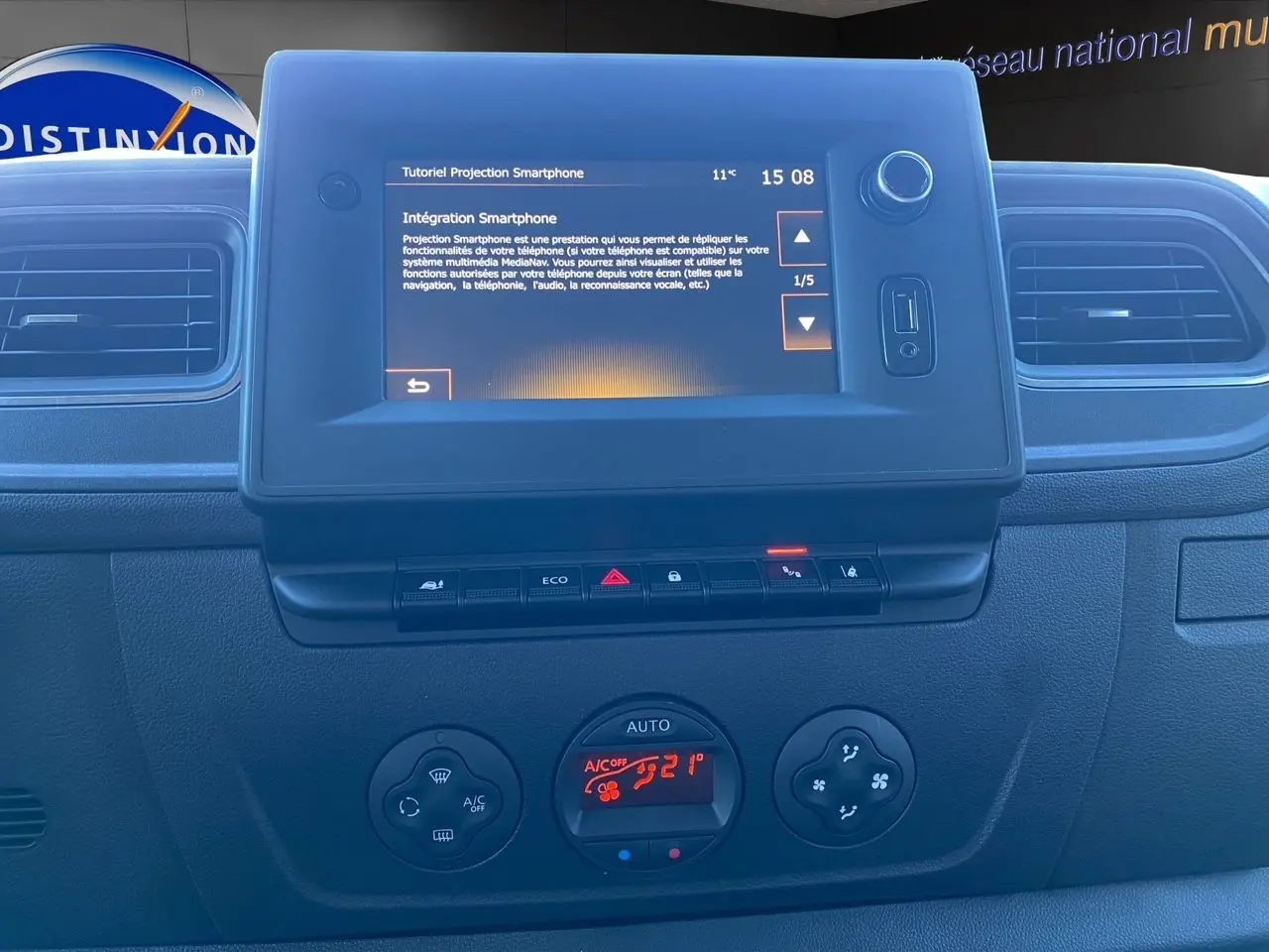 Tableau de bord du Nissan Interstar blanc 2022, vue frontale centrée sur l'écran tactile et commandes de climatisation.