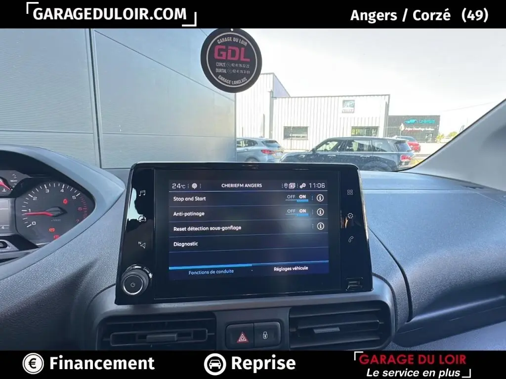 Vue intérieure du tableau de bord du Peugeot Rifter bleu 2024, avec écran tactile central affichant les réglages du véhicule.