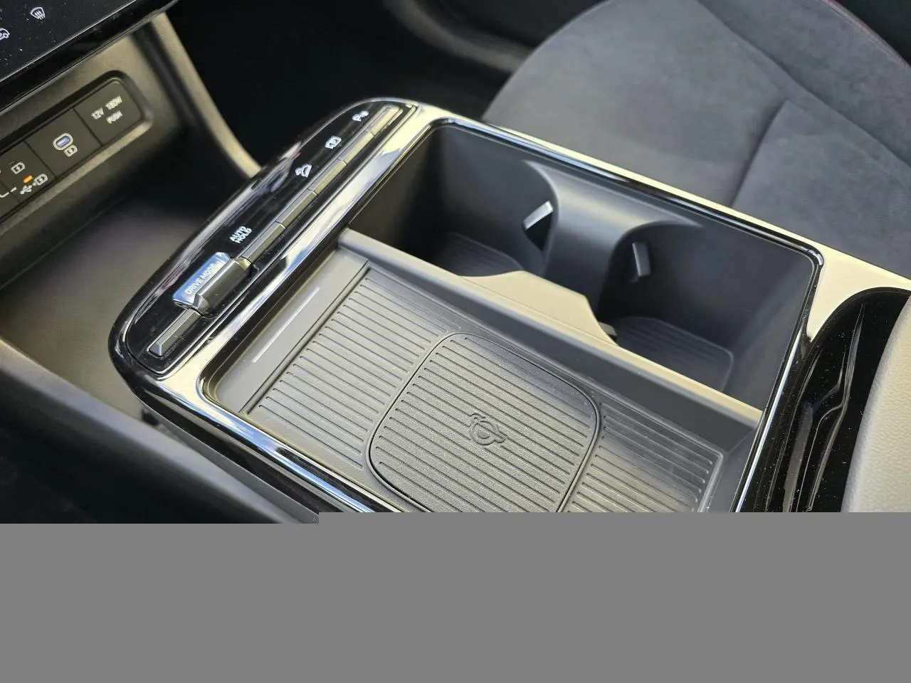 Vue rapprochée de la console centrale noire du Hyundai Tucson 2025, avec porte-gobelets et commandes de boîte auto.