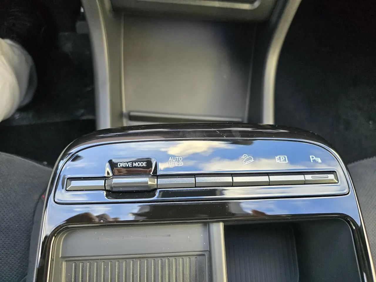 Gros plan sur la console centrale noire brillante du Hyundai Tucson IV N Line avec commandes Drive Mode et Auto Hold visibles.