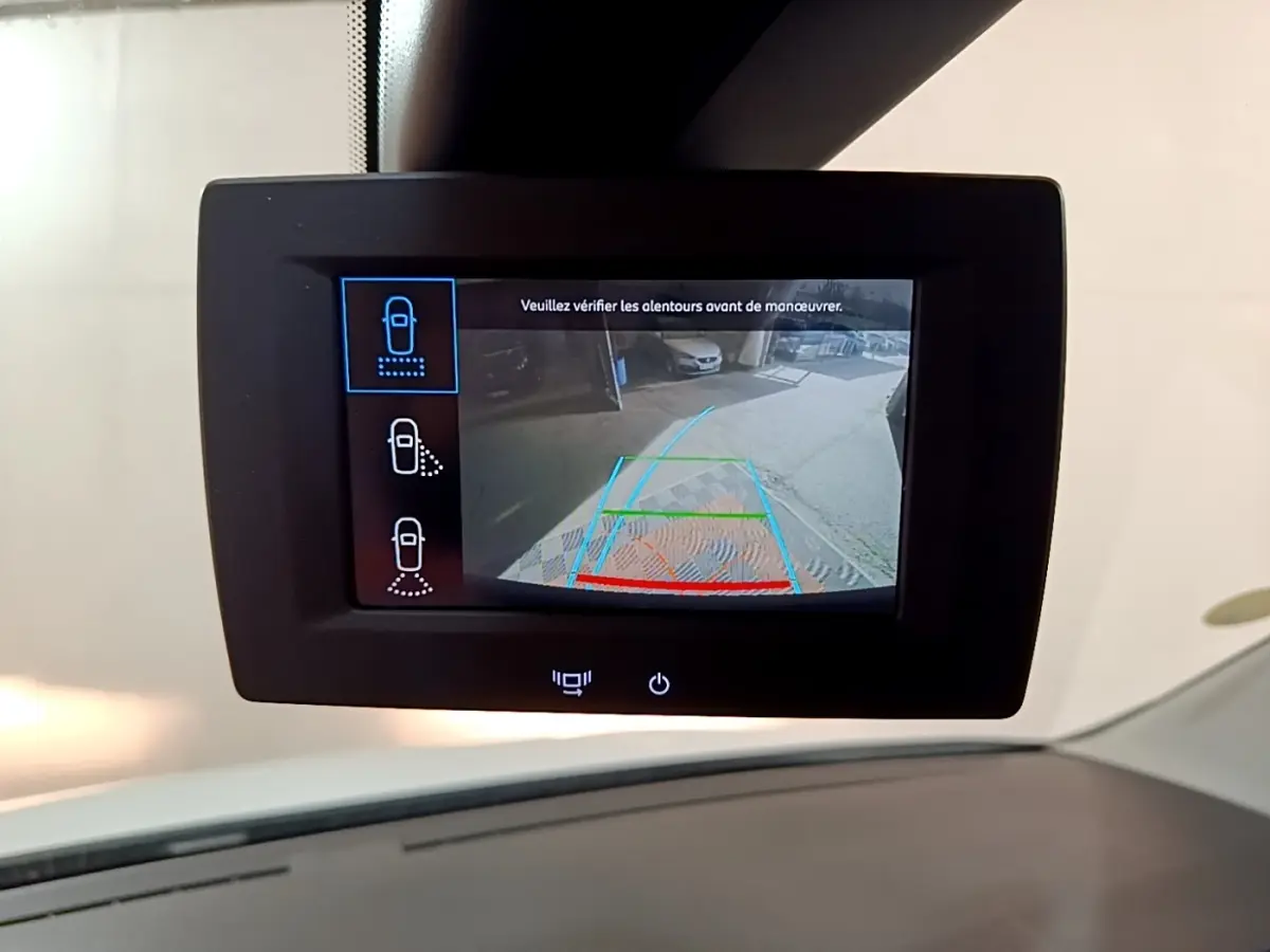 Écran tactile intérieur montrant la caméra de recul du Peugeot Partner blanc, vue depuis le tableau de bord.