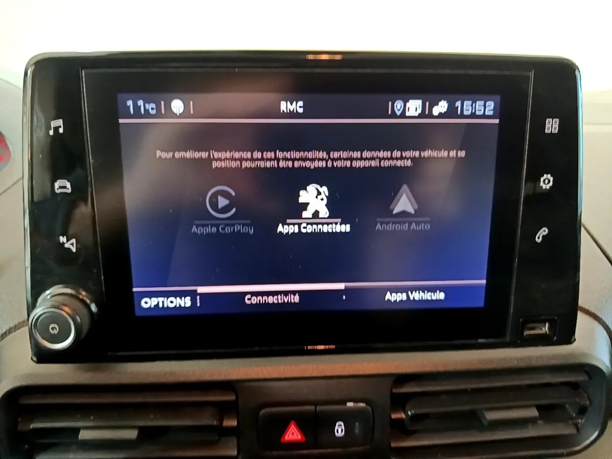 Écran tactile central du tableau de bord du Peugeot Partner blanc, affichant les options Apple CarPlay et Android Auto.
