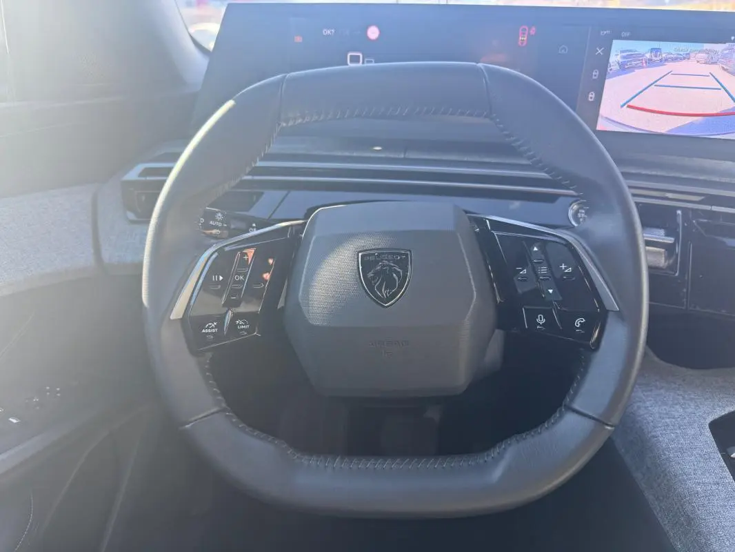 Vue frontale du volant cuir du Peugeot 3008 Hybrid 145 e-DCS6 Allure avec commandes intégrées et tableau de bord numérique.