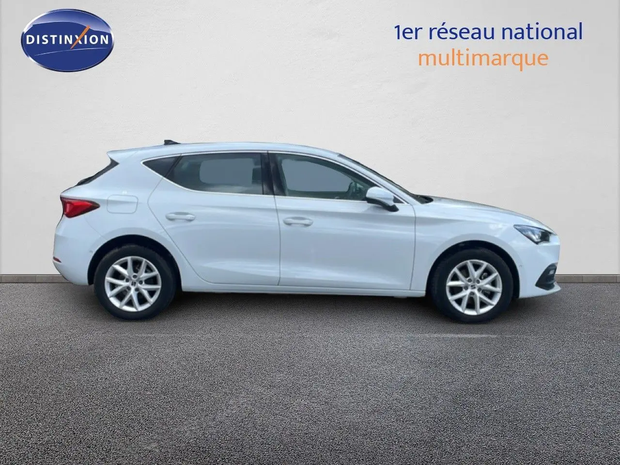 Vue latérale droite d'une SEAT Leon blanche neige métal 2025, avec jantes alliage et lignes épurées.