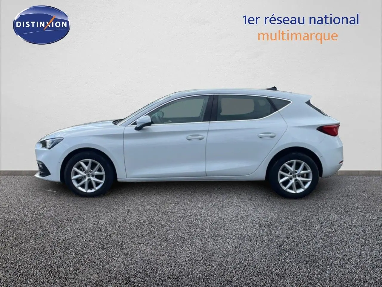 Vue de profil côté gauche d'une SEAT Leon 2025 blanche neige métal, avec jantes alliage et lignes épurées.