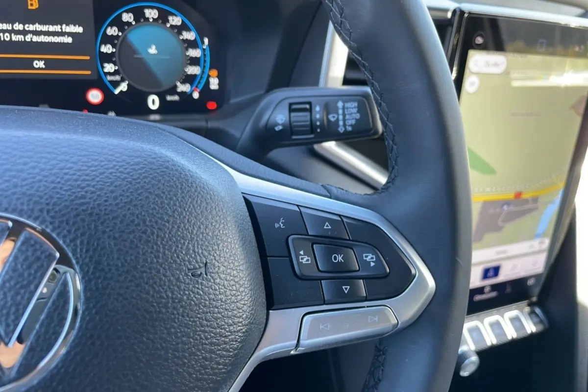 Gros plan sur le volant cuir multifonctions côté droit du Volkswagen Amarok 2026 avec tableau de bord digital et écran GPS.