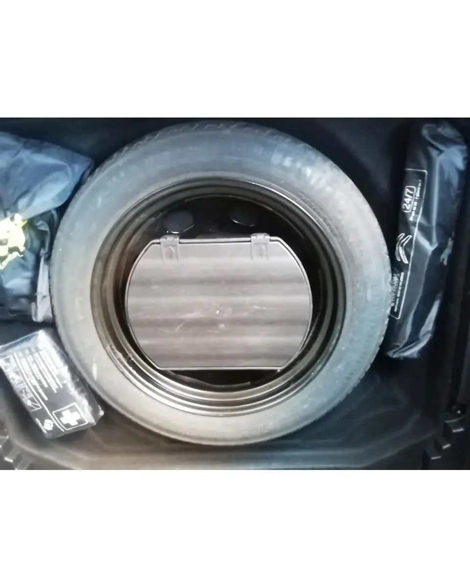 Vue en plongée sur la roue de secours et accessoires dans le coffre d'une Citroën C5 Aircross gris.