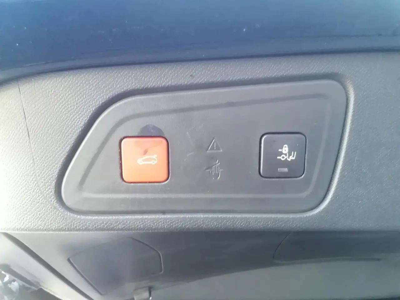 Gros plan sur les boutons d'ouverture et de verrouillage du hayon électrique du Citroën C5 Aircross gris.