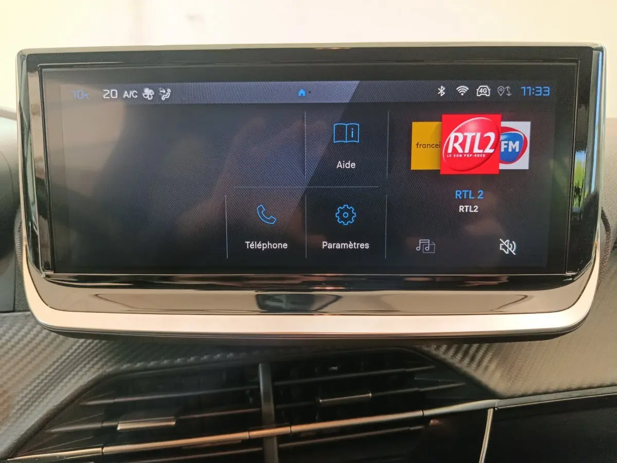 Écran tactile central de la Peugeot 208 PureTech 100 S&S Allure affichant les options téléphone et paramètres.