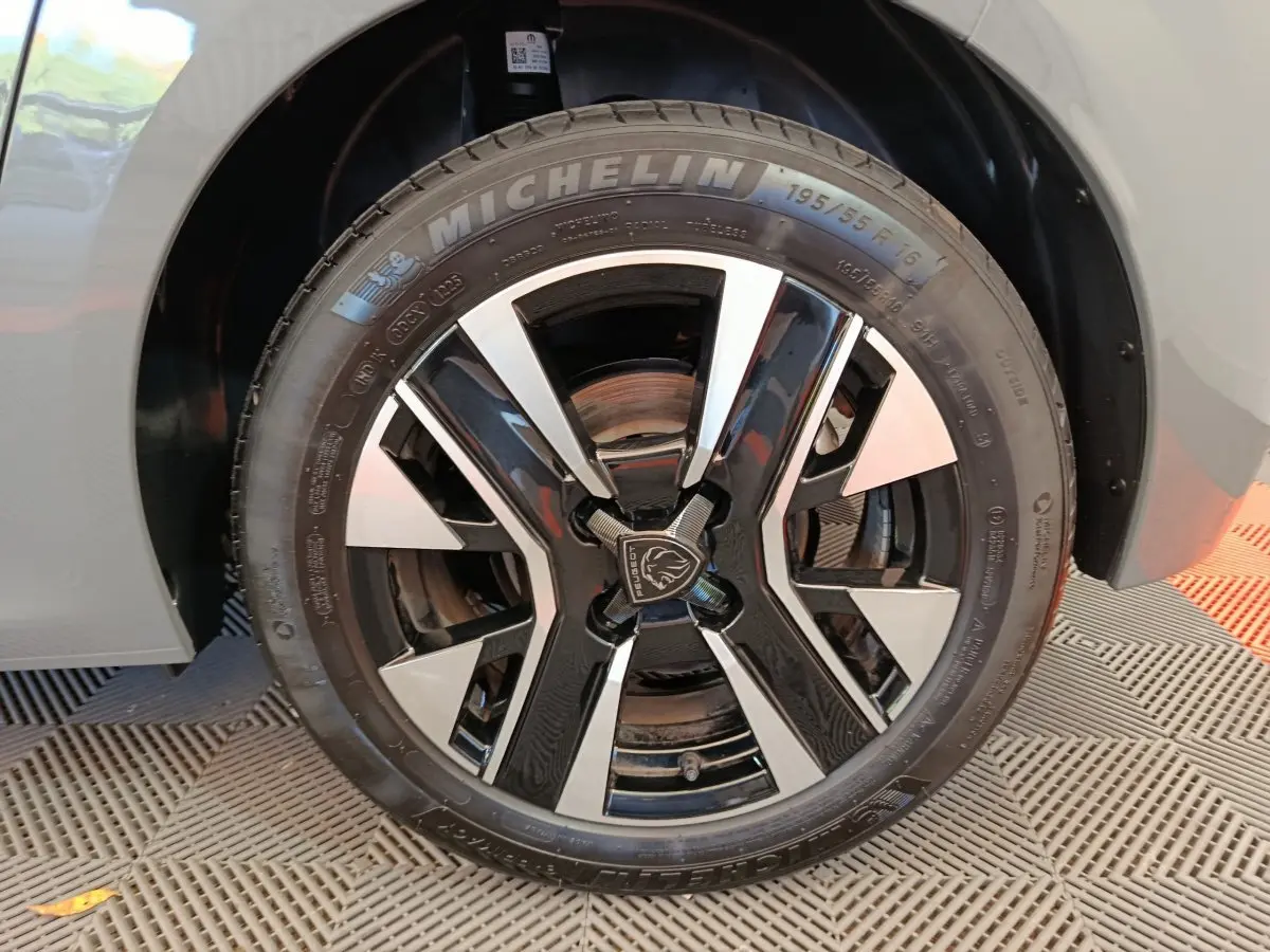 Gros plan sur la roue avant droite de la Peugeot 208 gris foncé avec jante alliage au design moderne et pneu Michelin.