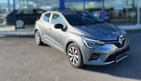 Renault Clio V gris schiste vue 3/4 avant droit, mettant en valeur ses phares LED et jantes bi-ton 16 pouces.