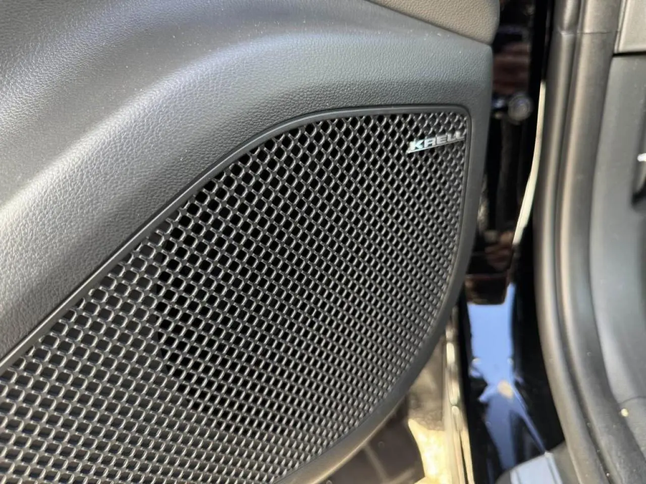 Gros plan sur le haut-parleur KRELL intégré à la porte intérieure du Hyundai Tucson noir Abyss Metal.