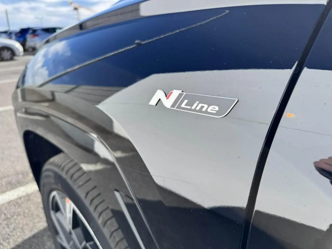 Gros plan sur l'aile avant gauche noire Abyss Metal du Hyundai Tucson 2025 avec badge N Line distinctif.