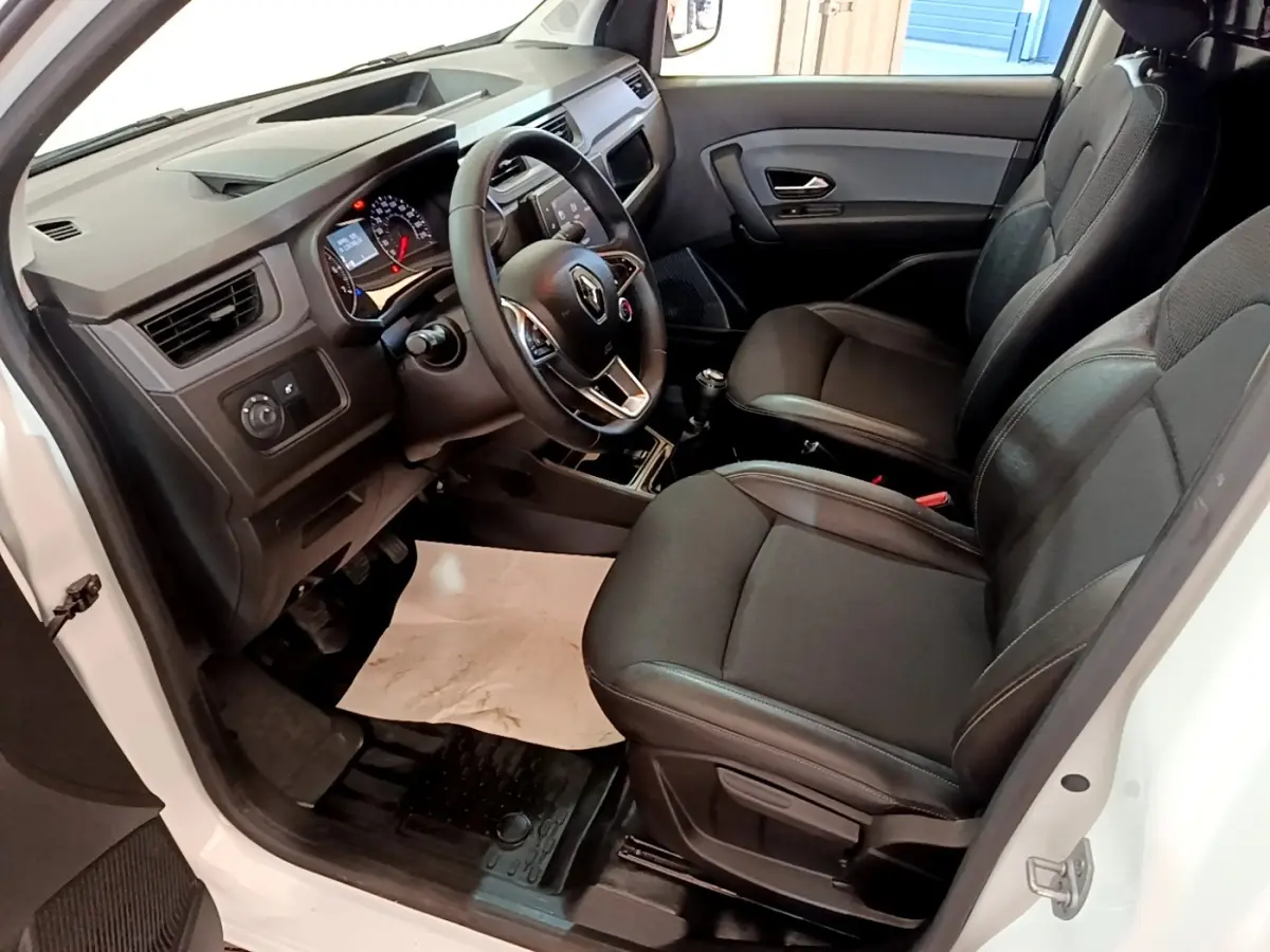 Vue intérieure côté conducteur de la Renault Express Confort blanche, montrant le tableau de bord et les sièges noirs.