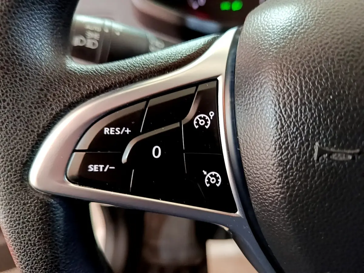 Gros plan sur les commandes de régulateur de vitesse au volant noir texturé du Renault Express blanc 2021.