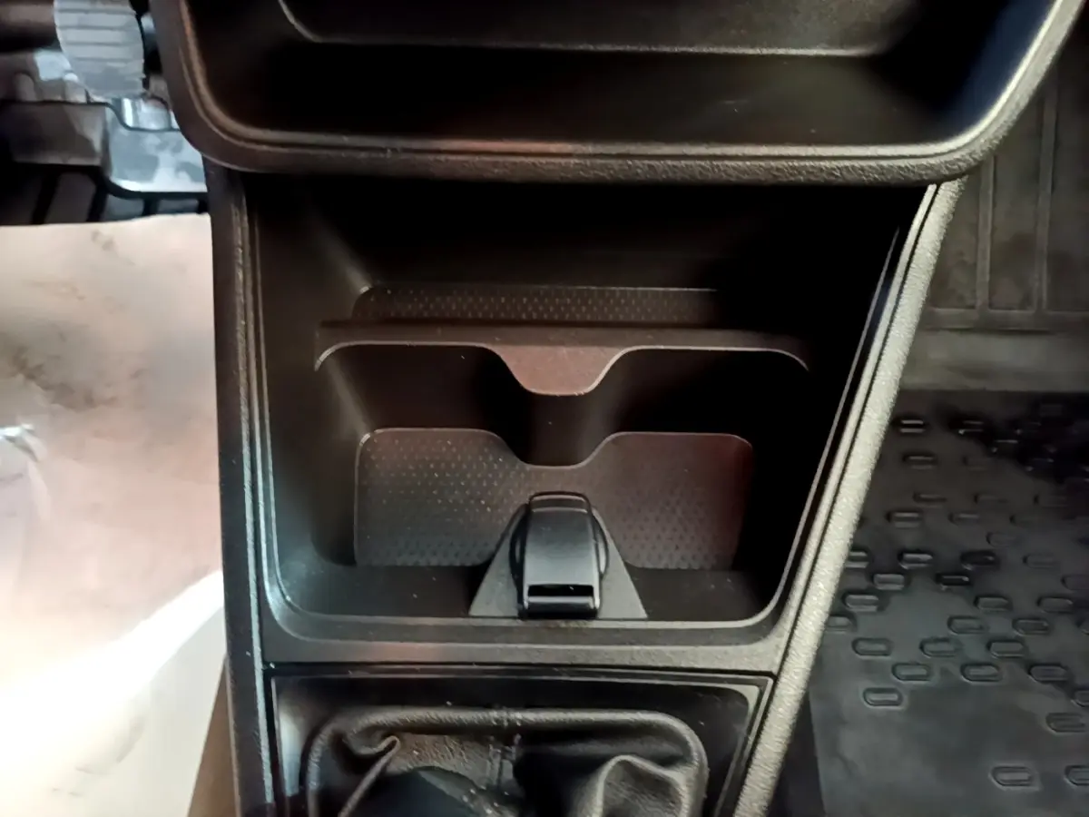 Vue rapprochée de la console centrale noire avec levier de vitesse manuel et espace de rangement du Renault Express blanc.