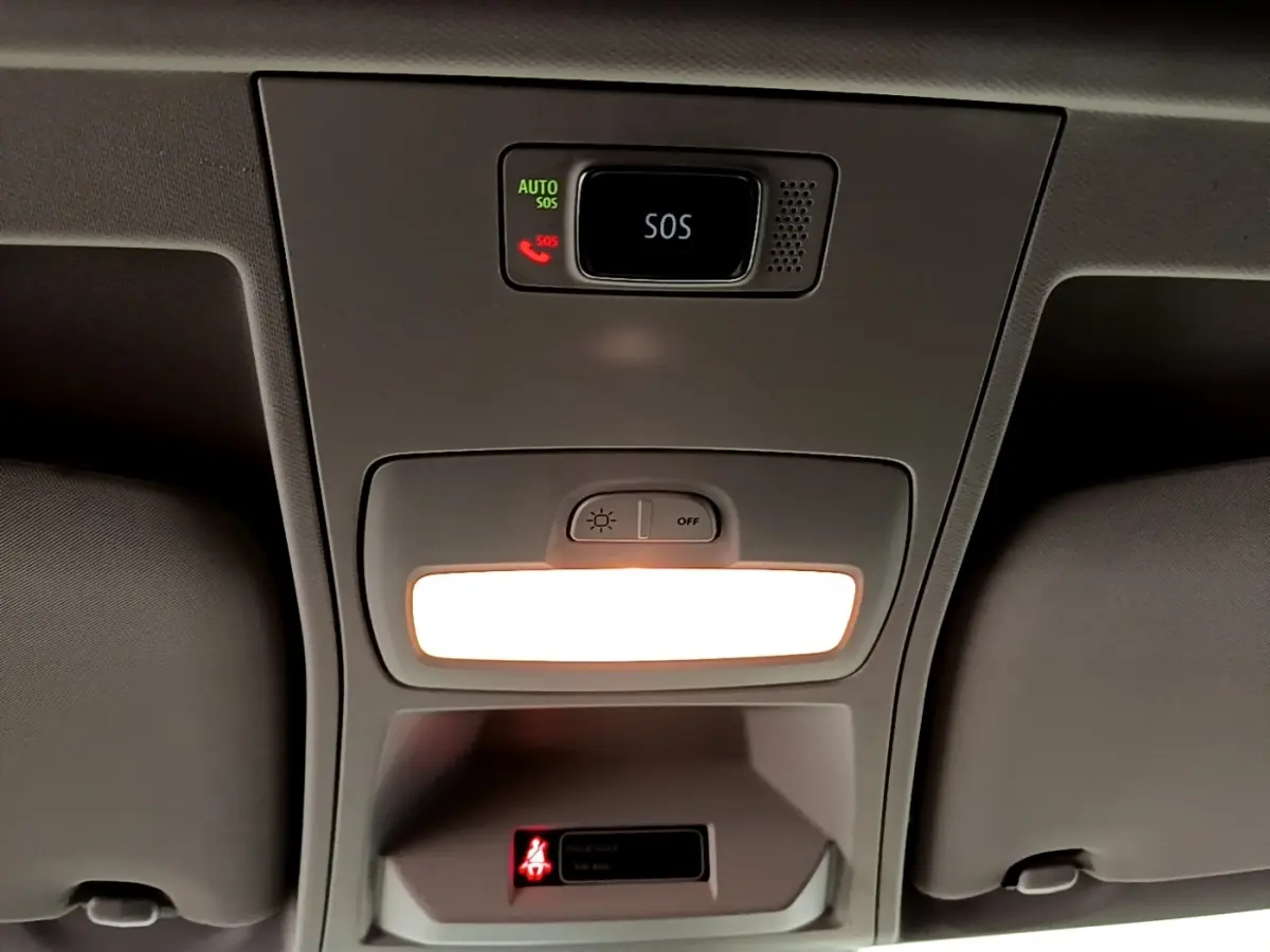 Plafonnier intérieur allumé vu de dessous dans un Renault Express blanc, avec bouton SOS et témoin de ceinture.