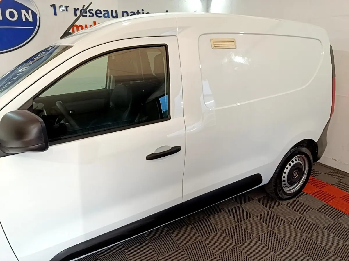 Vue de profil côté gauche d’un utilitaire Renault Express blanc avec porte latérale pleine et rétroviseur noir.