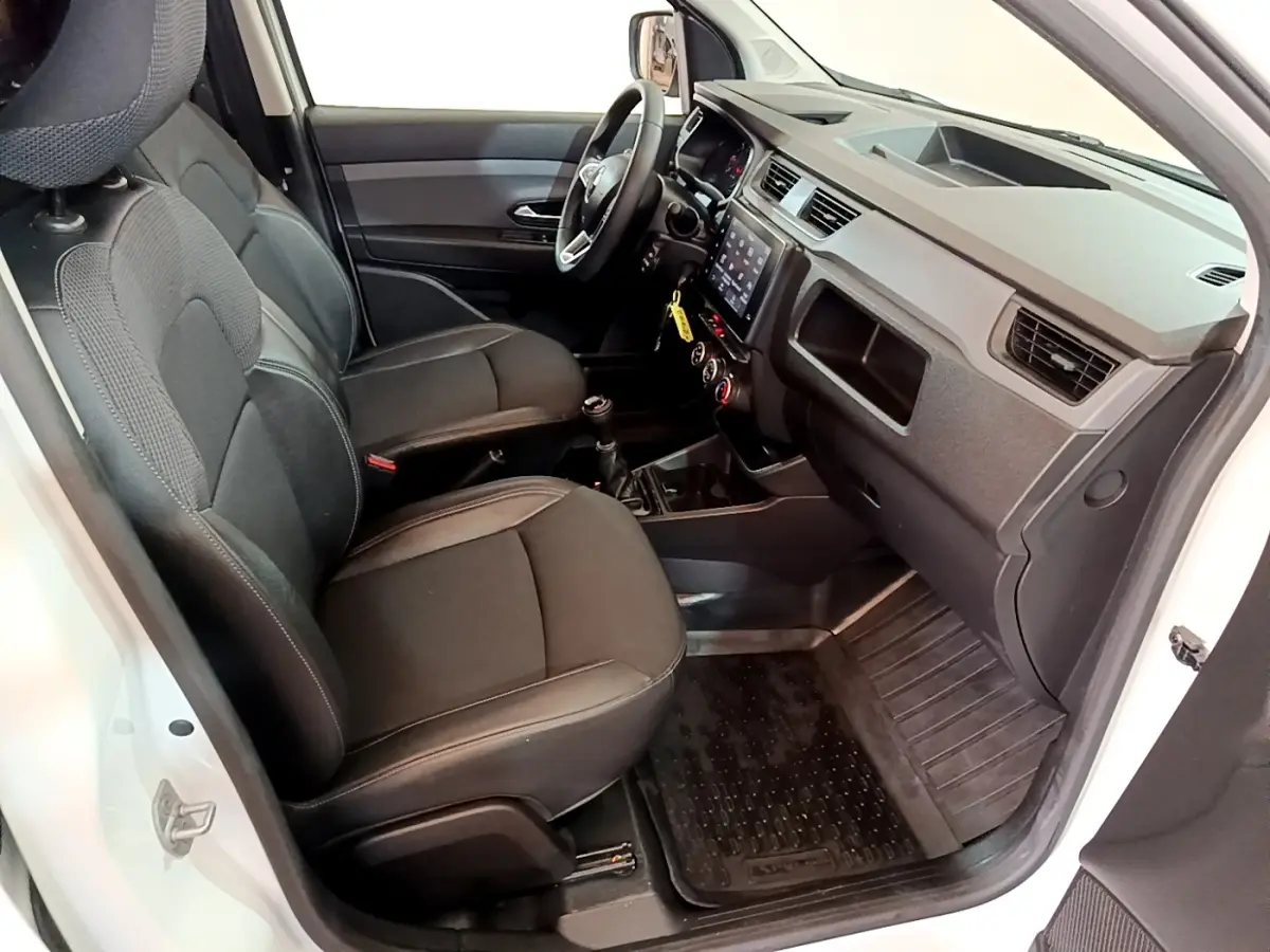 Vue intérieure côté conducteur du Renault Express blanc 2021, montrant sièges noirs et tableau de bord avec écran tactile.