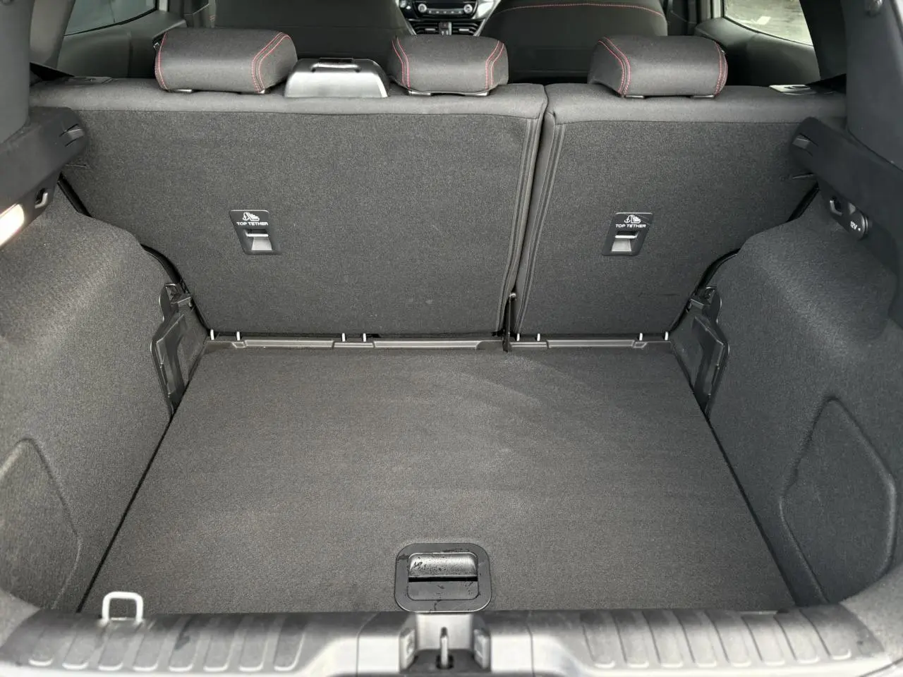 Vue du coffre arrière du Ford Puma gris Solar 2023, montrant les sièges arrière rabattus et le revêtement intérieur noir.