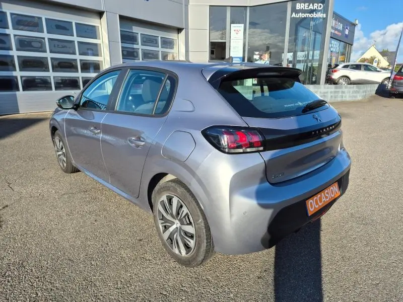 Peugeot 208 gris Artense vue 3/4 arrière droit, avec feux arrière distinctifs et plaque occasion orange.