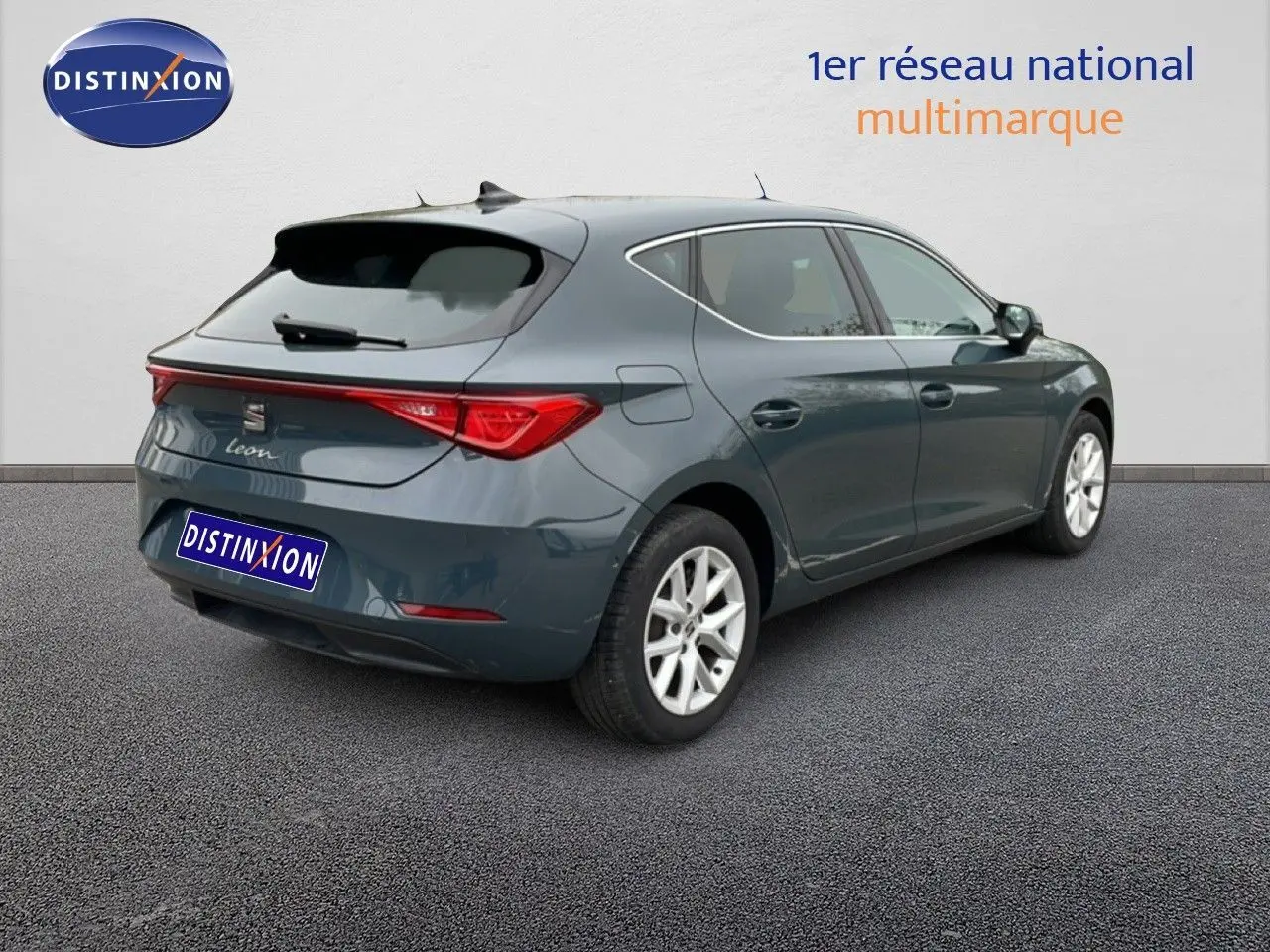 SEAT Leon bleu fjord vue 3/4 arrière droit, hayon et feux arrière distinctifs, jantes alliage argentées.