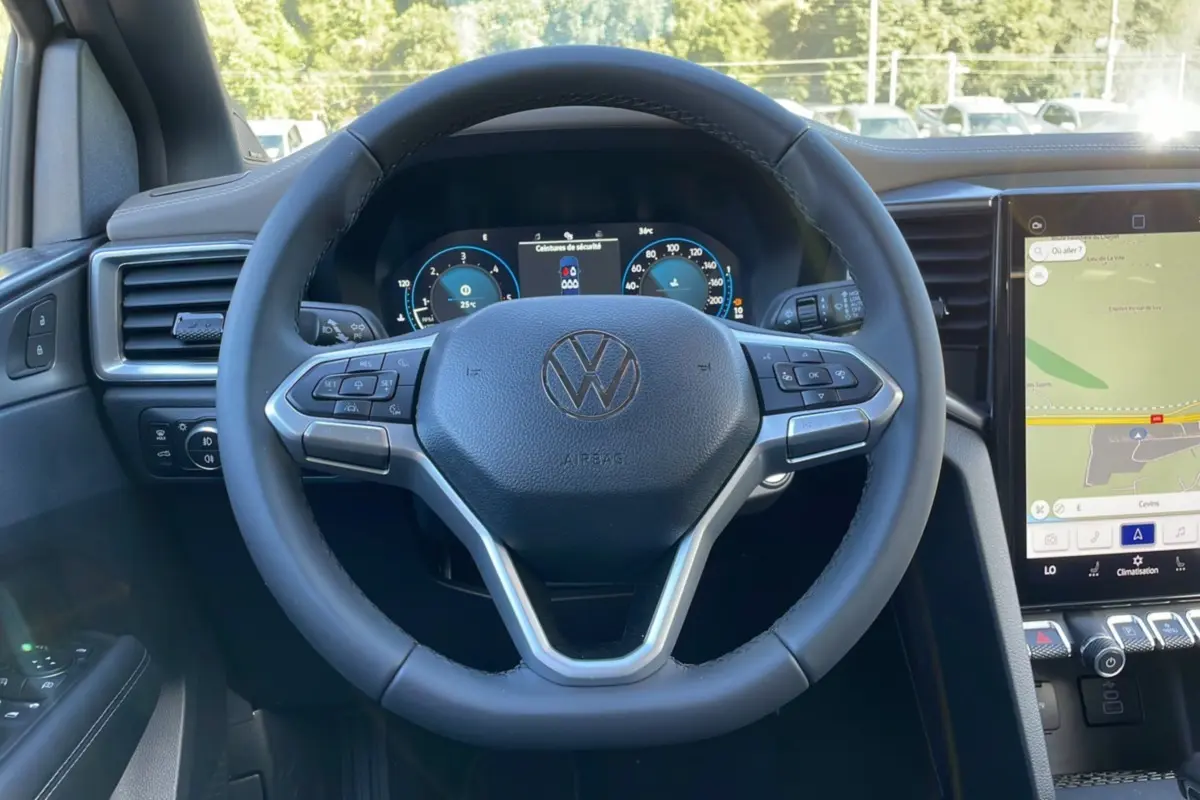 Volant cuir multifonctions Volkswagen Amarok V6 240 2026 vu de face avec tableau de bord digital et écran GPS tactile.