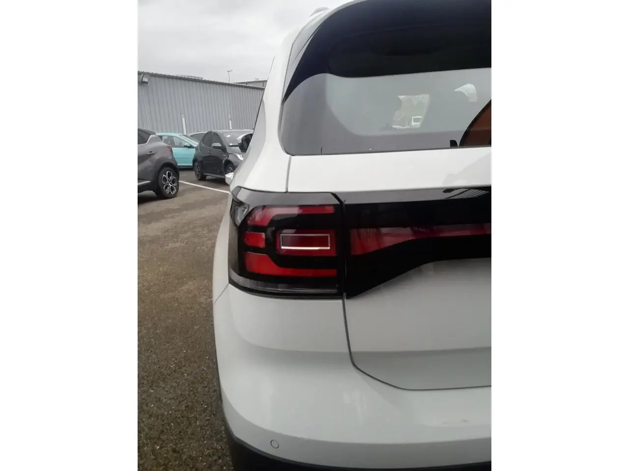 Vue arrière gauche d'un Volkswagen T-Cross blanc 2020 avec feux arrière LED et lunette teintée.
