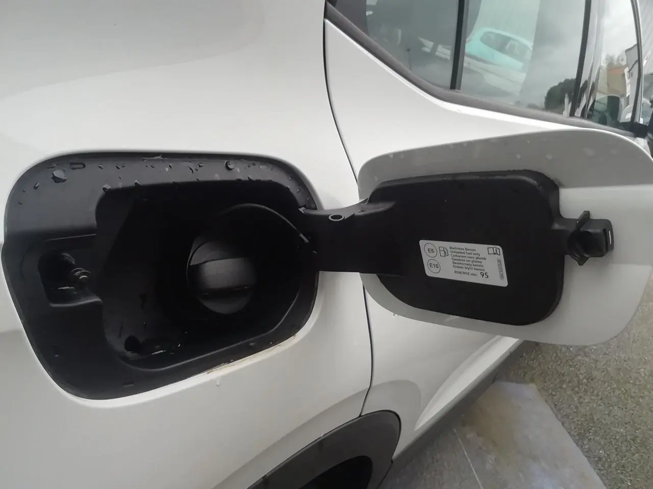 Vue rapprochée de la trappe à carburant ouverte côté gauche du Volkswagen T-Cross blanc 2020.