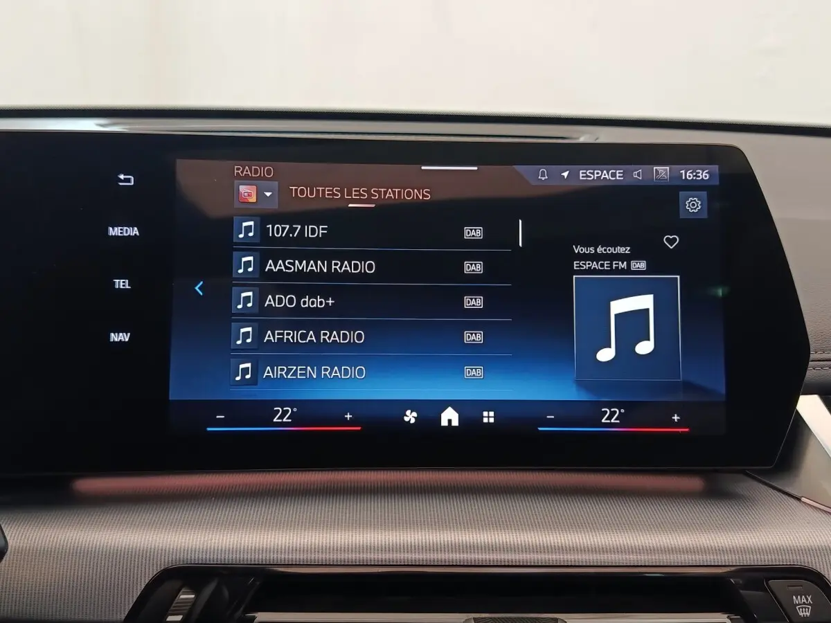 Écran tactile central affichant les stations radio dans l’habitacle du BMW X1 xDrive25e M Sport gris foncé.