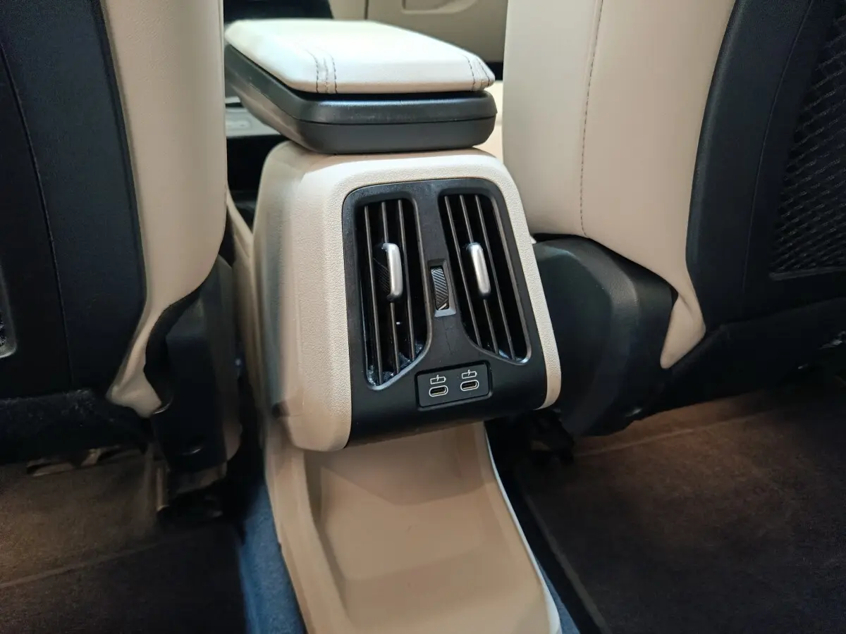 Vue rapprochée des aérateurs arrière et ports USB-C sur la console centrale beige du BMW X1 xDrive25e M Sport 2024.