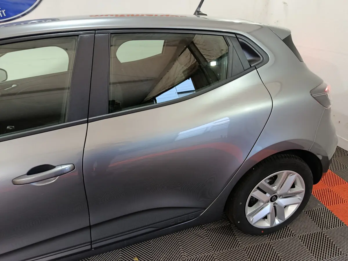 Profil côté gauche d'une Renault Clio gris foncé 2025, mettant en valeur la ligne fluide et la jante alliage distinctive.