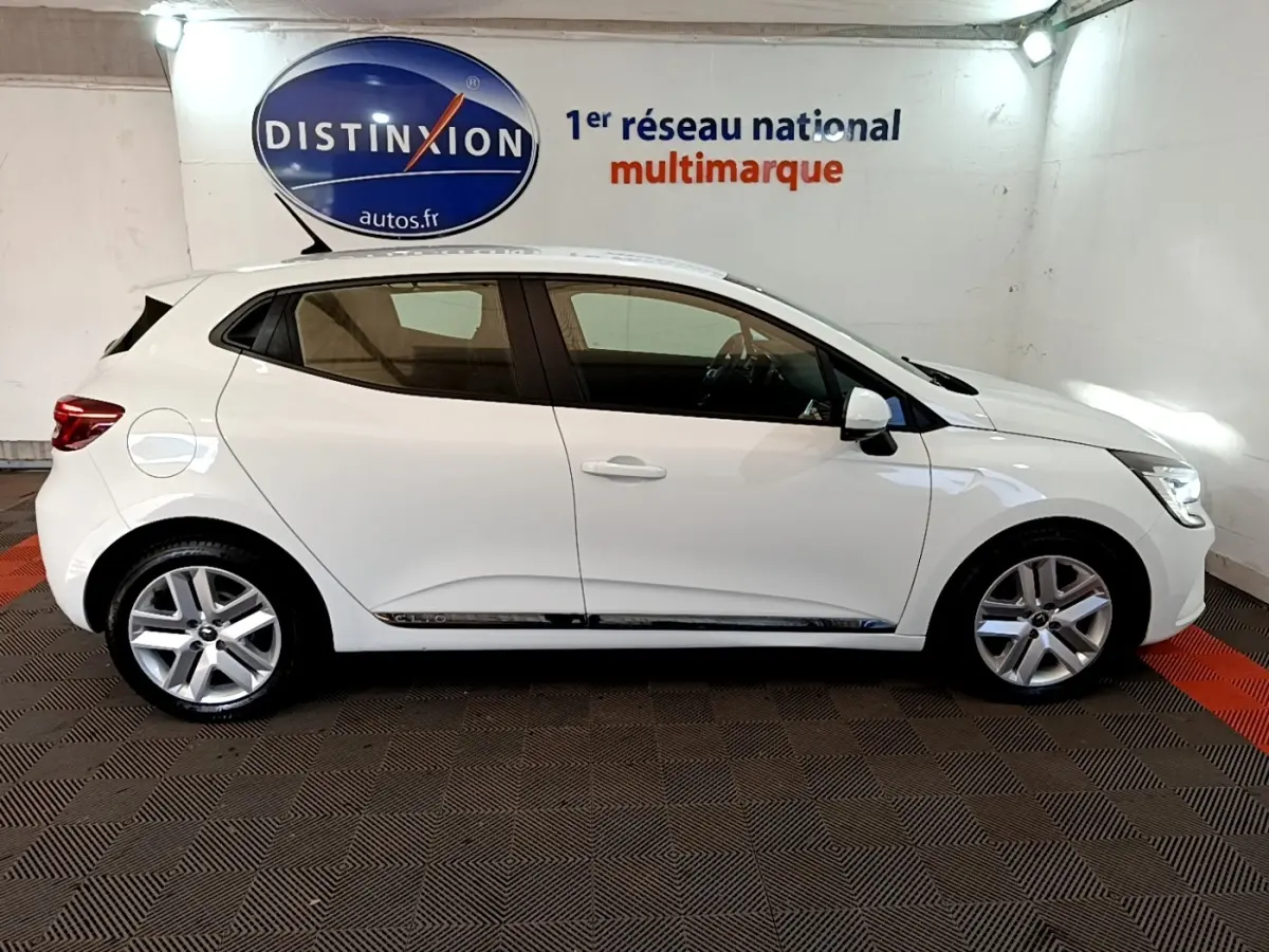 Profil côté gauche d'une Renault Clio Business Blue dCi 115 blanche, vue en intérieur avec jantes alliage et vitres teintées.