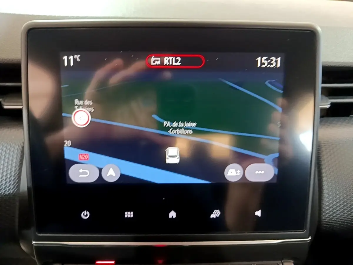 Écran tactile central de navigation 3D dans une Renault Clio Business Blue dCi 115 blanche, vue intérieure frontale.