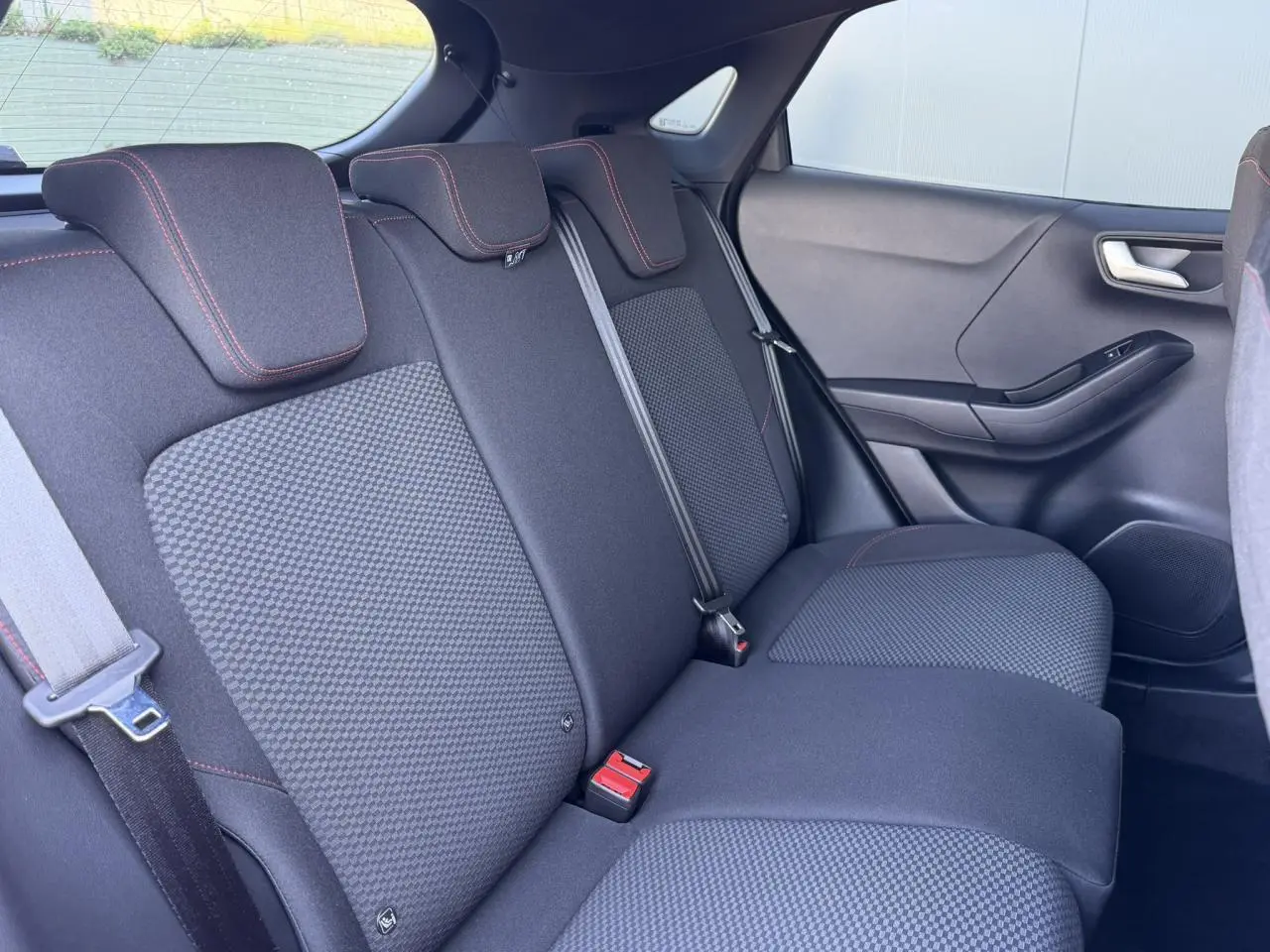 Vue intérieure côté droit des sièges arrière noirs avec surpiqûres rouges du Ford Puma Ecoboost 155 BVA ST Line 2023.
