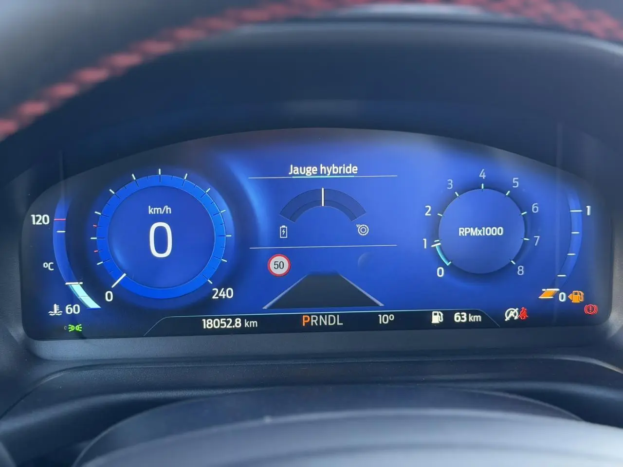 Combiné d'instrumentation numérique bleu du Ford Puma 2023, affichant vitesse, régime moteur et jauge hybride.