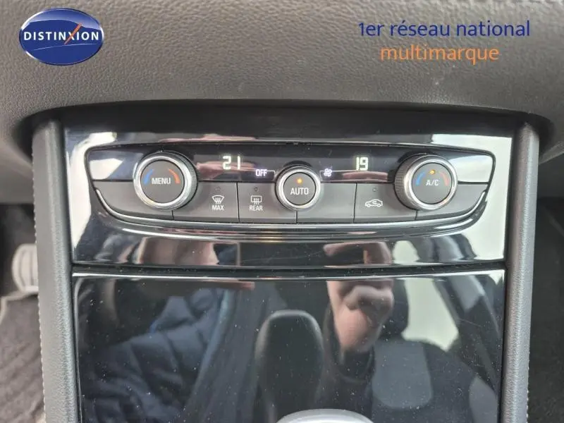 Vue rapprochée du tableau de bord de l’Opel Grandland X 2020, montrant les commandes de climatisation automatique bi-zone.