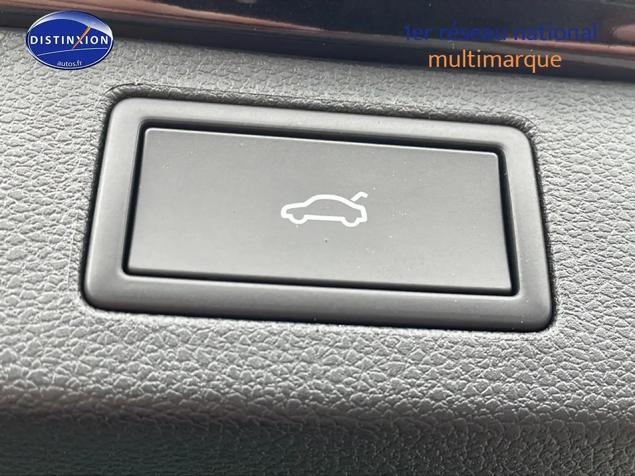 Bouton d'ouverture du hayon sur tableau de bord texturé, intérieur du Skoda Kamiq noir 2026.