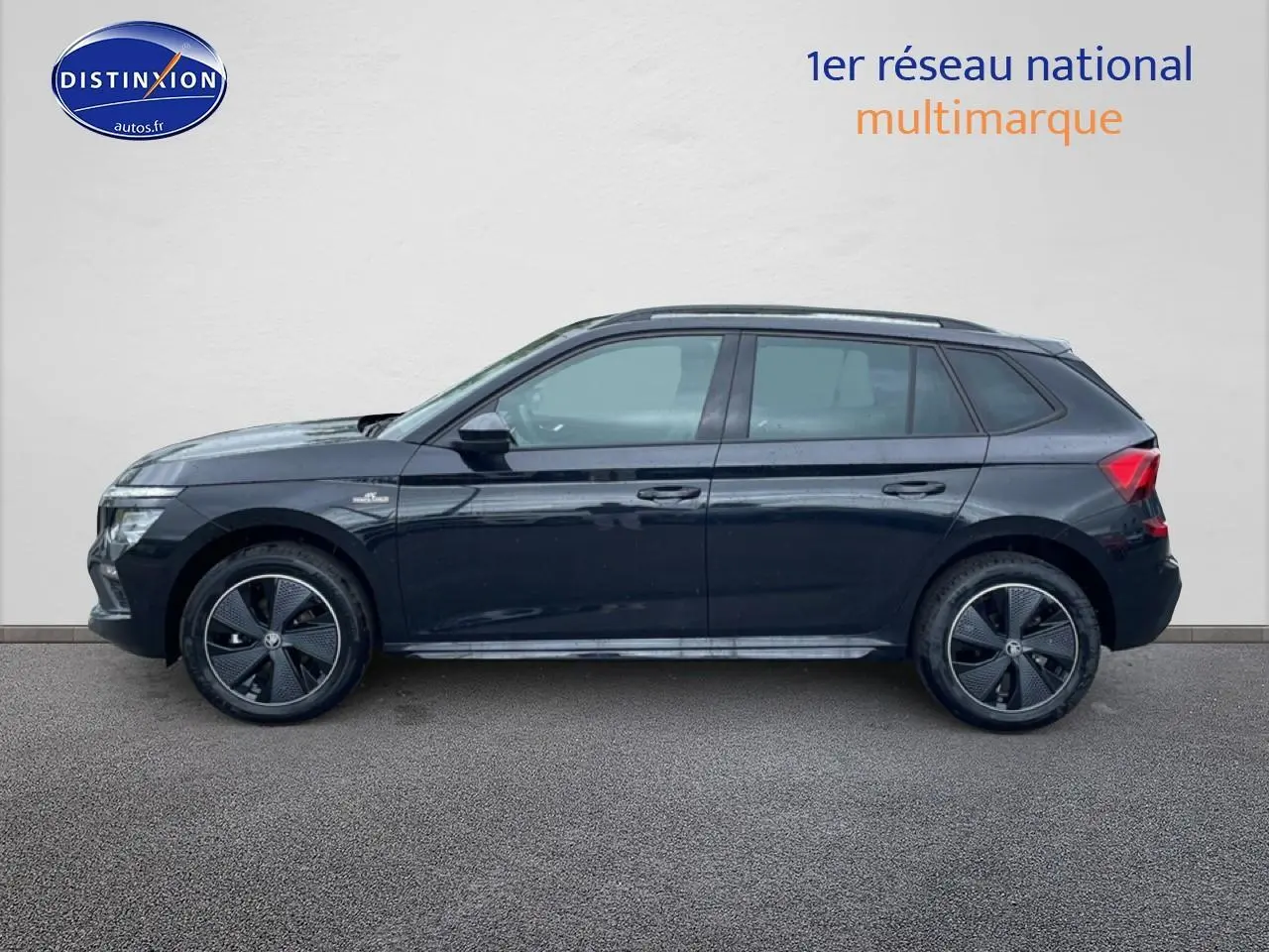 Vue de profil côté gauche d'un Skoda Kamiq noir 2026 avec jantes alu et barres de toit visibles.