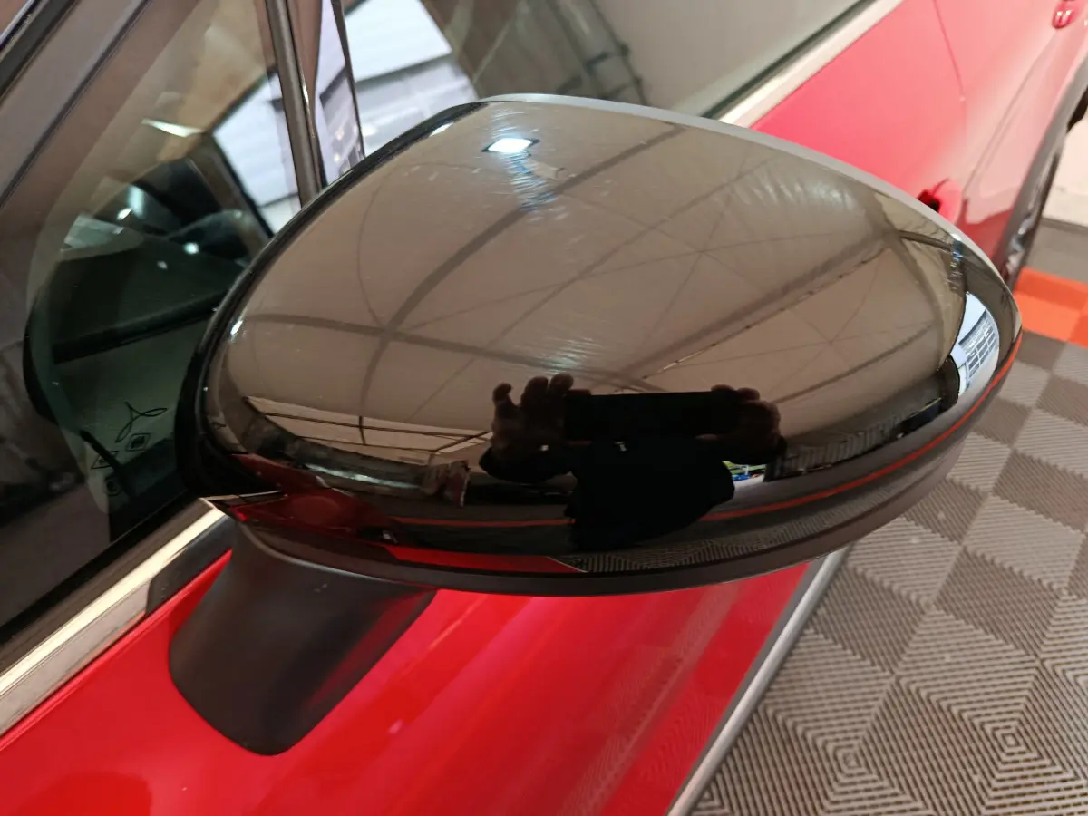 Rétroviseur droit noir brillant sur Renault Captur rouge 2024, vue rapprochée côté conducteur.
