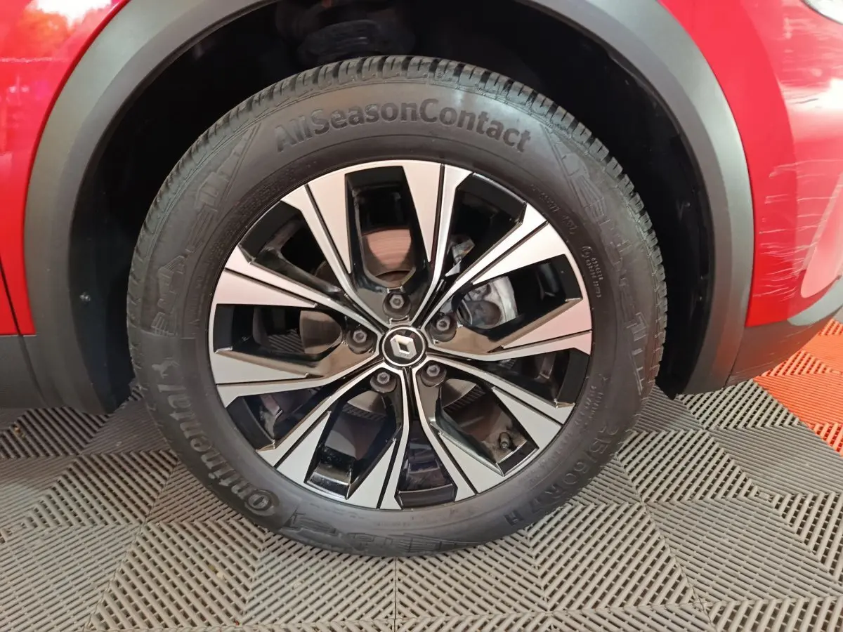 Gros plan sur la roue avant droite du Renault Captur rouge 2024 avec jante alliage et pneu Continental AllSeasonContact.