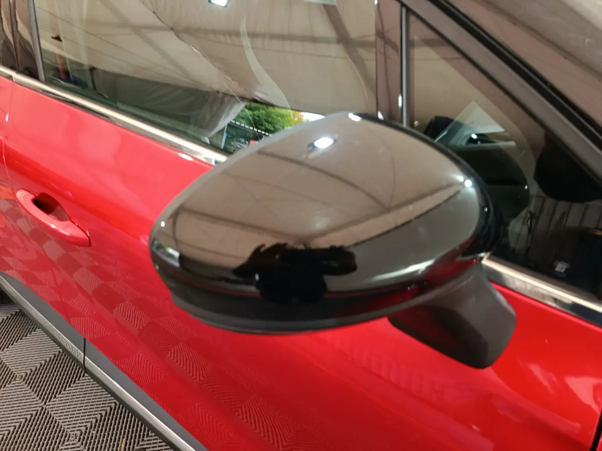 Rétroviseur noir en gros plan côté gauche sur une Renault Captur Techno TCe 90 rouge 2024.
