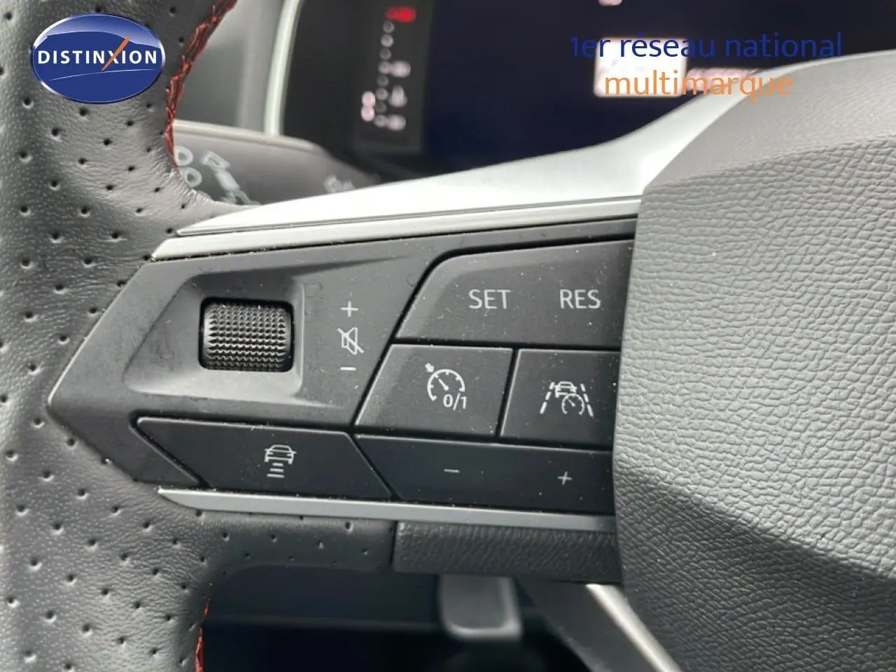 Gros plan sur les commandes au volant en cuir perforé noir du SEAT Arona 2025, avec boutons de régulateur de vitesse et assistance.