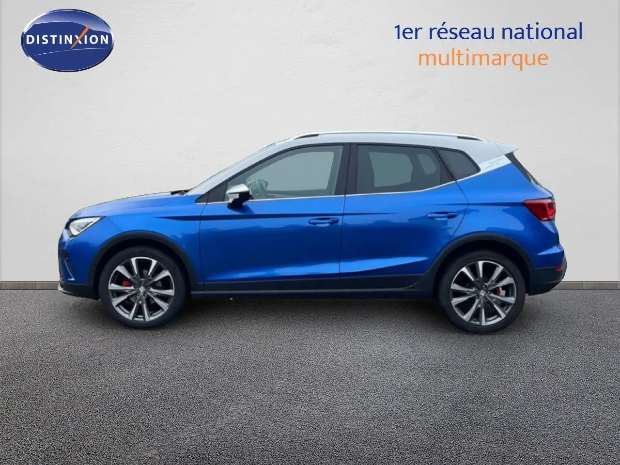 Vue latérale droite d'un SEAT Arona bleu saphir métallisé avec toit blanc, jantes alliage et finitions sport.