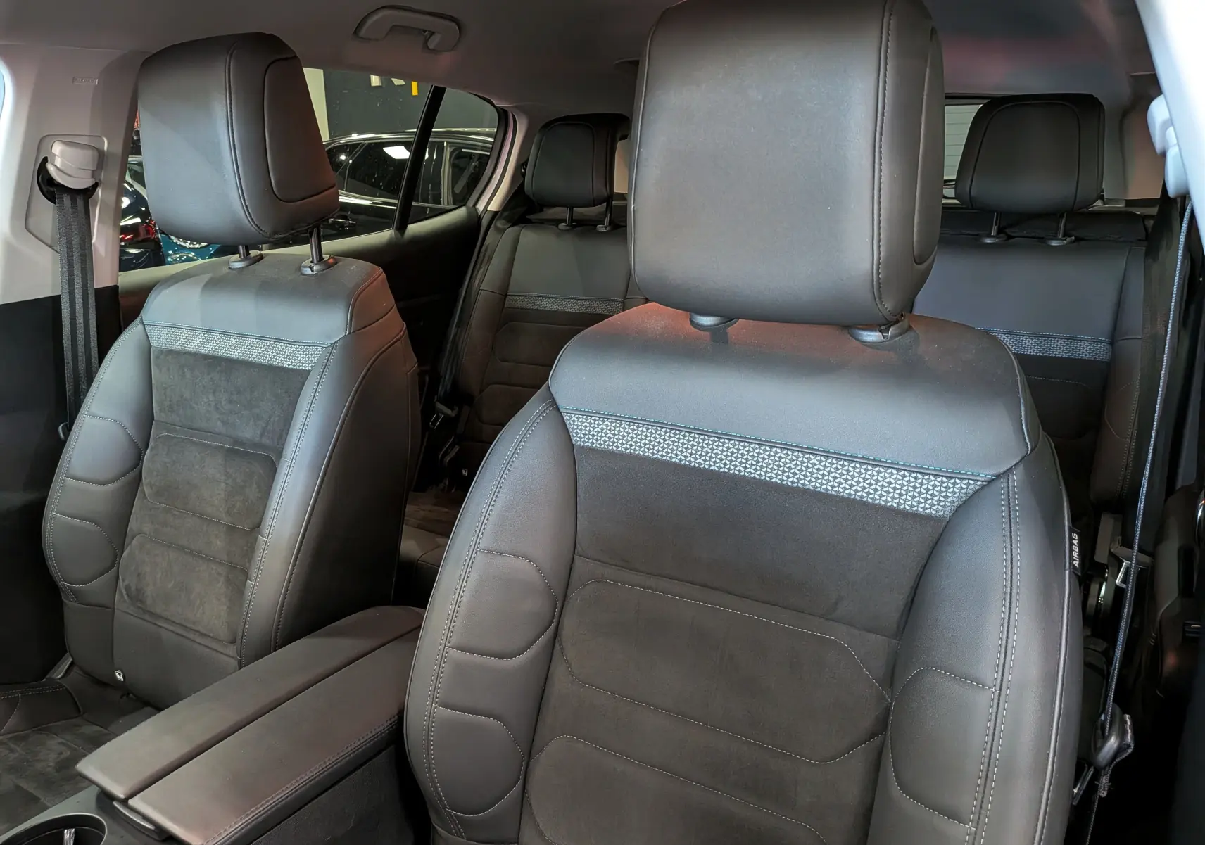 Vue intérieure centrée sur les sièges avant en cuir noir et alcantara du Citroën C5 Aircross 2025, finition biton.