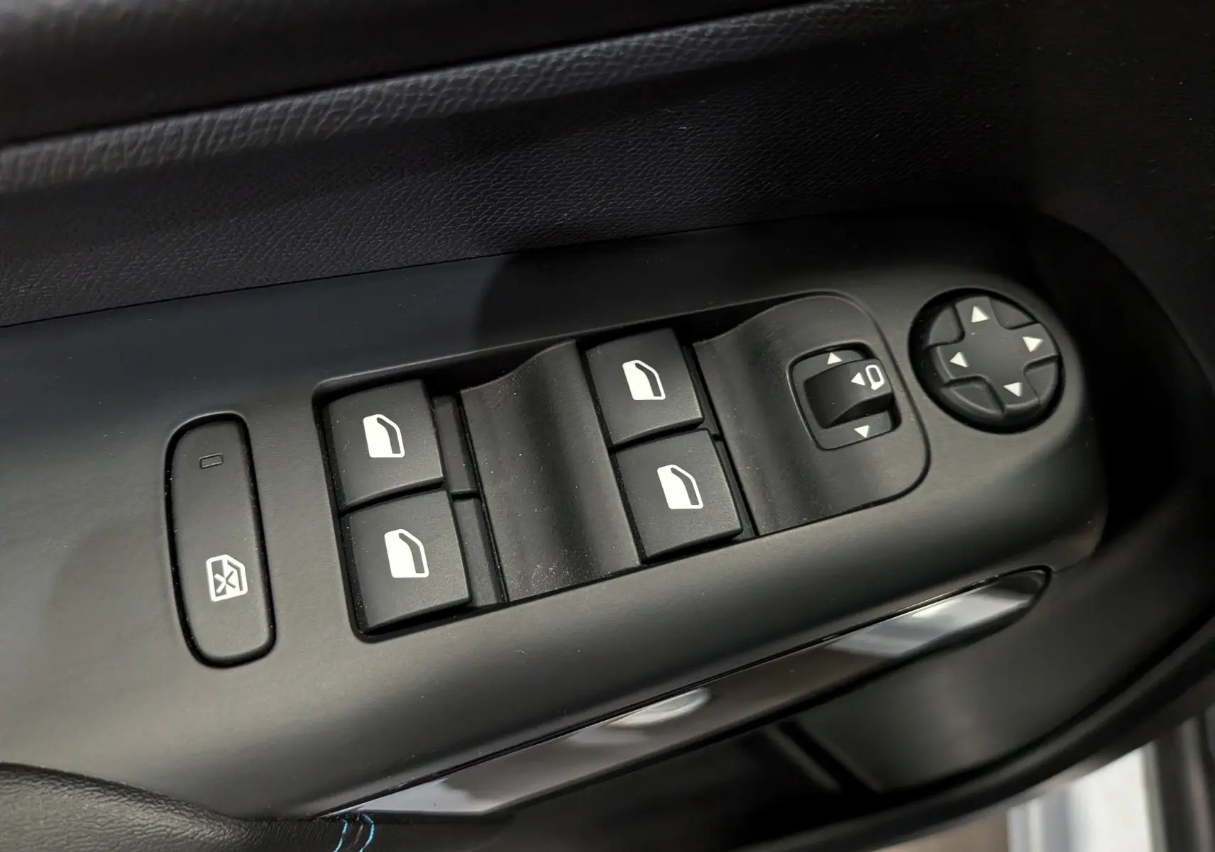 Gros plan sur les commandes de lève-vitres et réglage des rétroviseurs côté conducteur du Citroën C5 Aircross 2025.