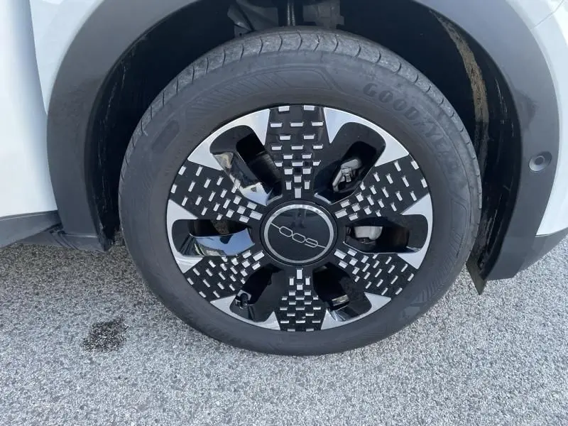 Gros plan sur la roue avant droite du Fiat 600 blanc 1.2 Hybrid 2025 avec jante au design noir et argent distinctif.
