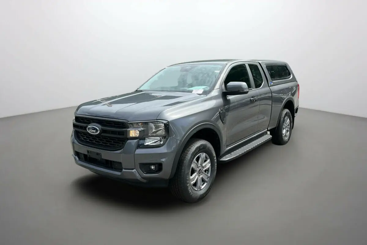 Ford Ranger gris carbone vu en 3/4 avant droit avec hard-top et marchepieds latéraux intégrés.