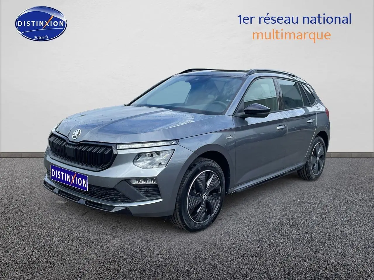 Skoda Kamiq gris graphite en 3/4 avant droit, avec jantes alu noires et toit panoramique en verre.