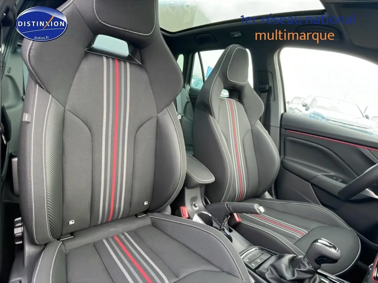 Vue intérieure sur les sièges avant sport gris graphite avec bandes rouges et grises du Skoda Kamiq Monte Carlo 2026.